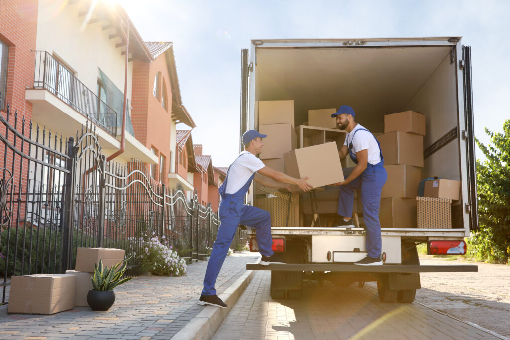 Workers unloading boxes from moving truck.